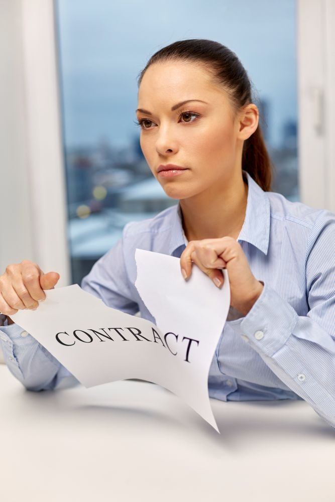business agreement and legal concept - businesswoman terminating contract at office. businesswoman terminating contract at office