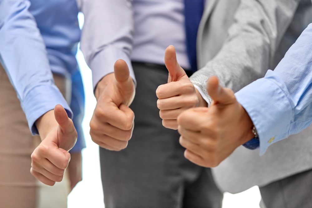 people, gesture and success concept - close up of business team hands showing thumbs up. close up of business team hands showing thumbs up