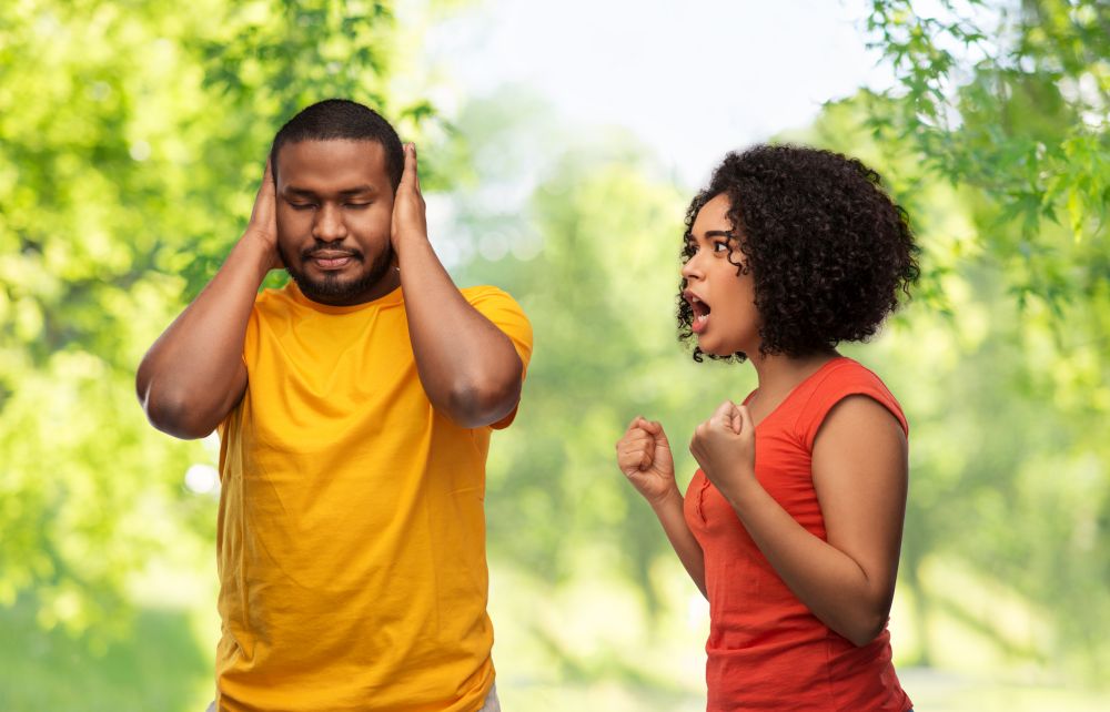 relationships and people concept - unhappy african american couple having argument over green natural background. african american couple having argument