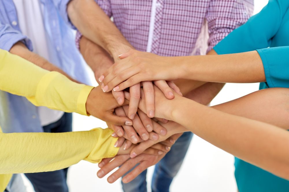 teamwork, unity and friendship concept - close up of group of students stacking hands. group of students stacking hands