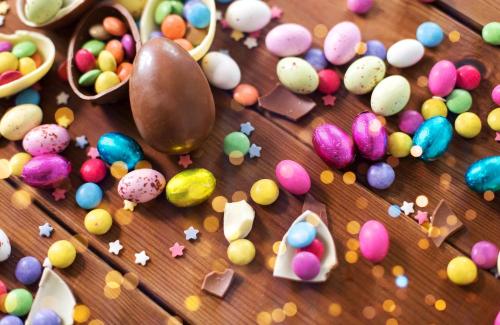 easter, sweets and confectionery concept - close up of chocolate eggs and candy drops on wooden table. chocolate eggs and candy drops on wooden table