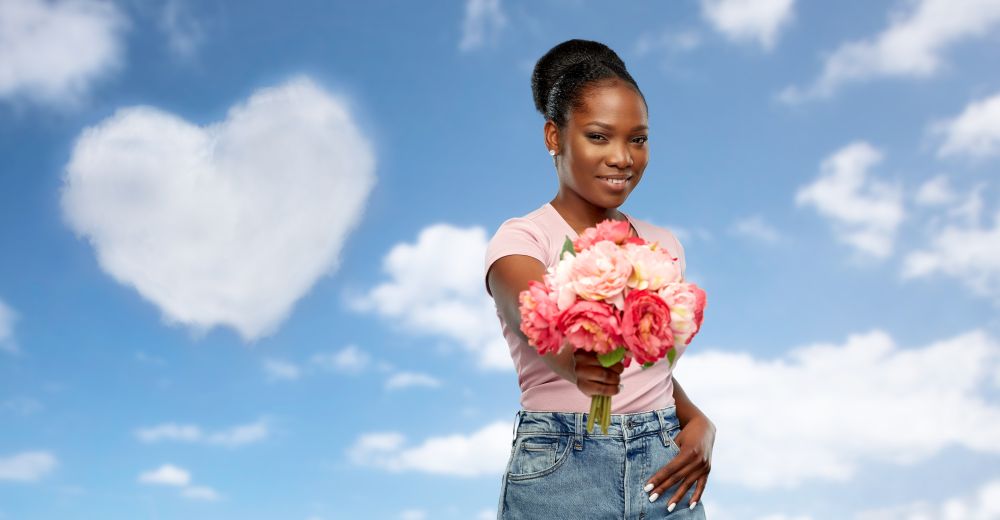 love, valentine&rsquo;s day and people concept - happy african american young woman with bunch of peony flowers over grey background. happy african american woman with bunch of flowers