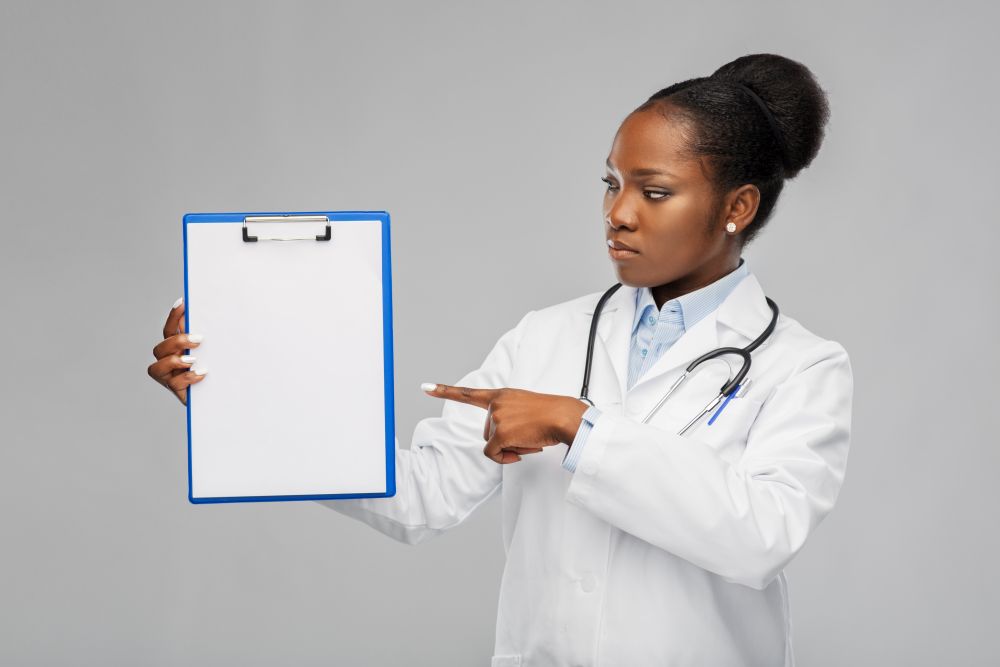 medicine, profession and healthcare concept - african american female doctor in white coat with clipboard and stethoscope over grey background. african american female doctor with clipboard