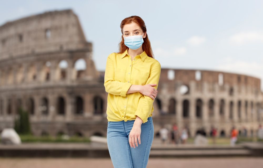 health, safety and pandemic concept - young woman wearing protective medical mask for protection from virus disease over coliseum in rome, italy background. young woman in protective medical mask