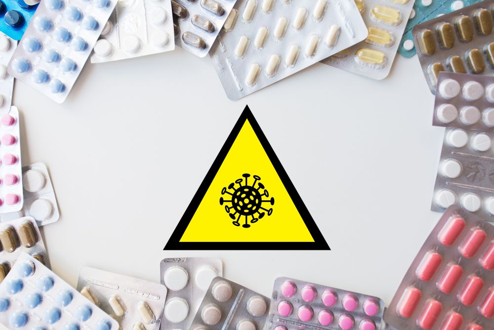 medicine, epidemic and healthcare concept - coronavirus caution sign and different drugs in pills. coronavirus caution sign and drugs in pills