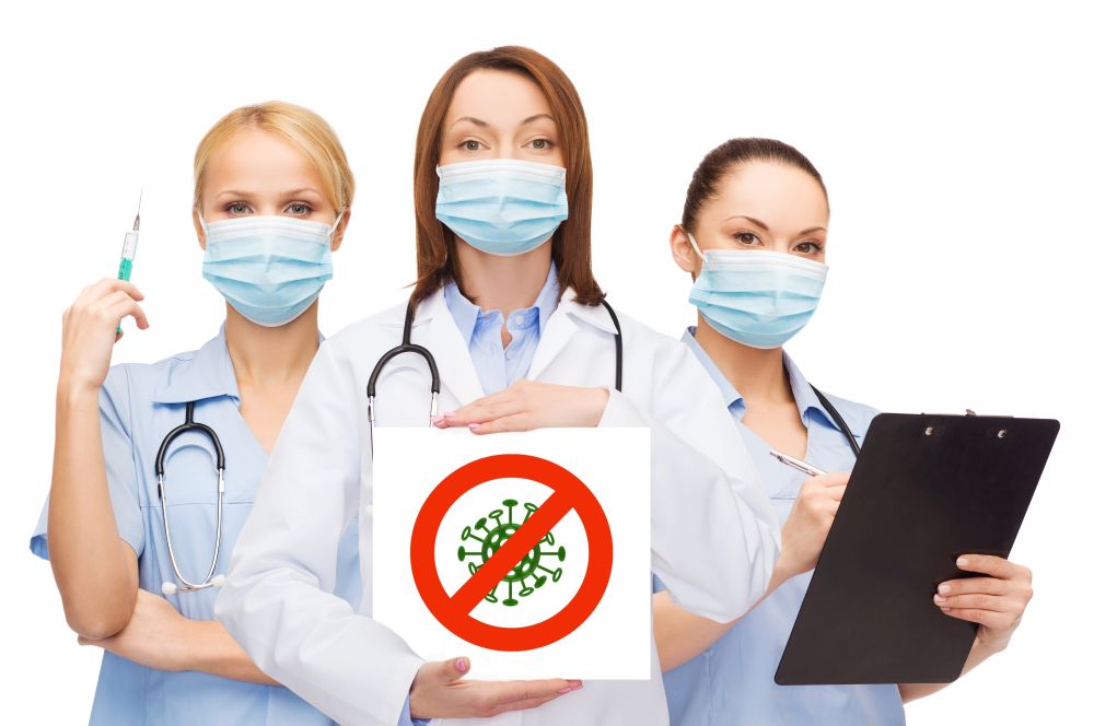 health, medicine and pandemic concept - female doctor and nurses wearing protective medical masks holding coronavirus sign on white background. african american doctor with coronavirus sign
