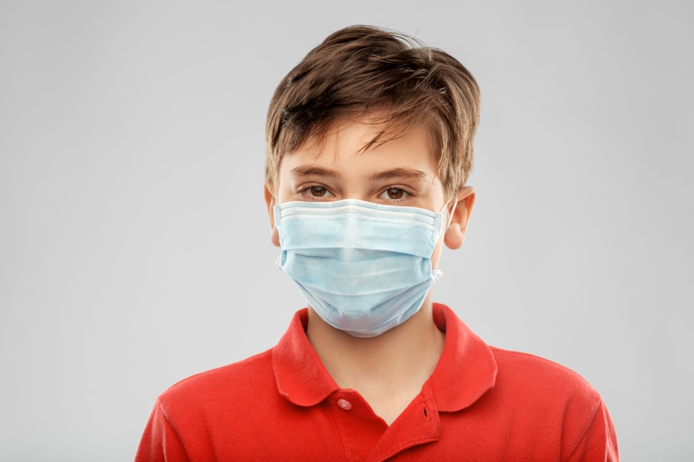 health protection, safety and pandemic concept - boy in protective medical mask over grey background. boy in protective medical mask