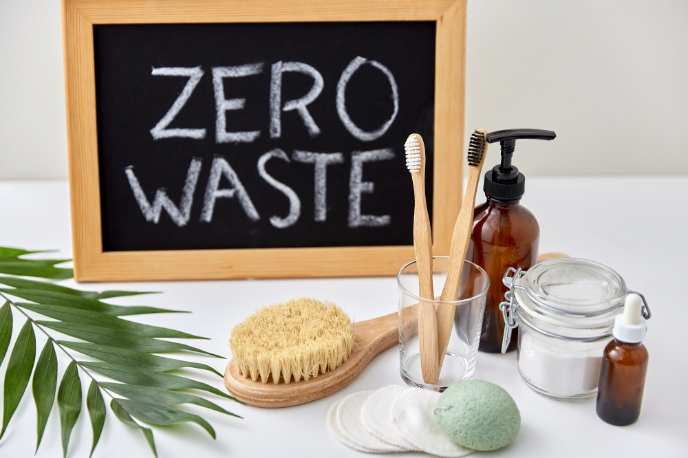 beauty, sustainability and eco living concept - natural cosmetics, bodycare, hygienic eco products and chalkboard with zero waste words or lettering on white background. natural cosmetics, bodycare and hygienic products