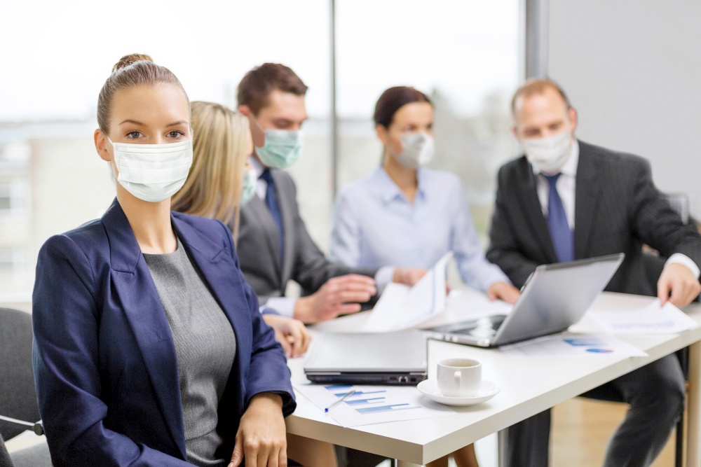 business and pandemic concept - businesswoman wearing face protective medical mask for protection from virus disease at office with team on the back. businesswoman in mask with colleagues at office
