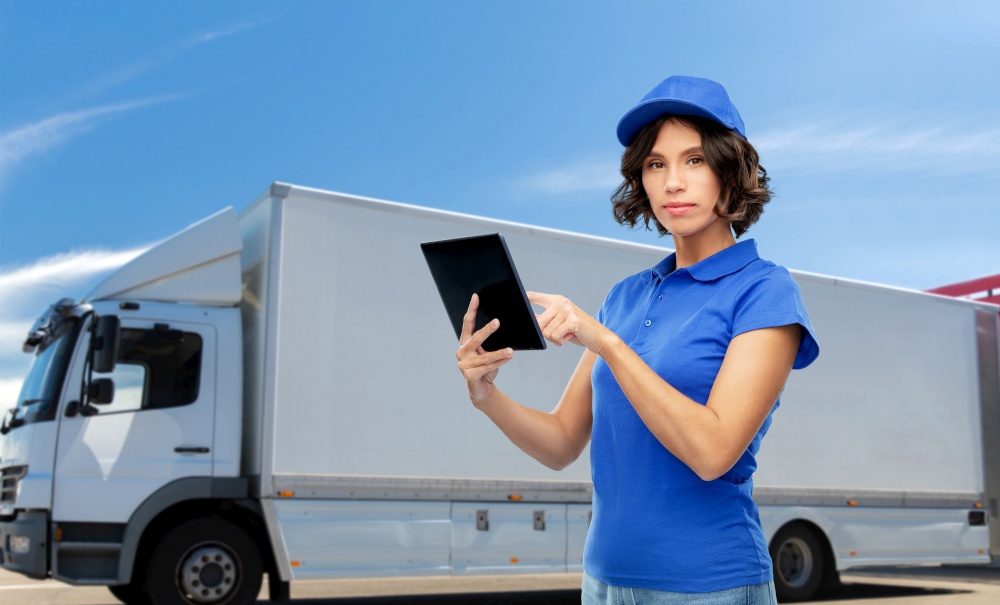 shipping, freight transportation and shipment concept - delivery girl or warehouse worker in blue uniform with tablet pc computer over truck on background. delivery girl with tablet computer over truck