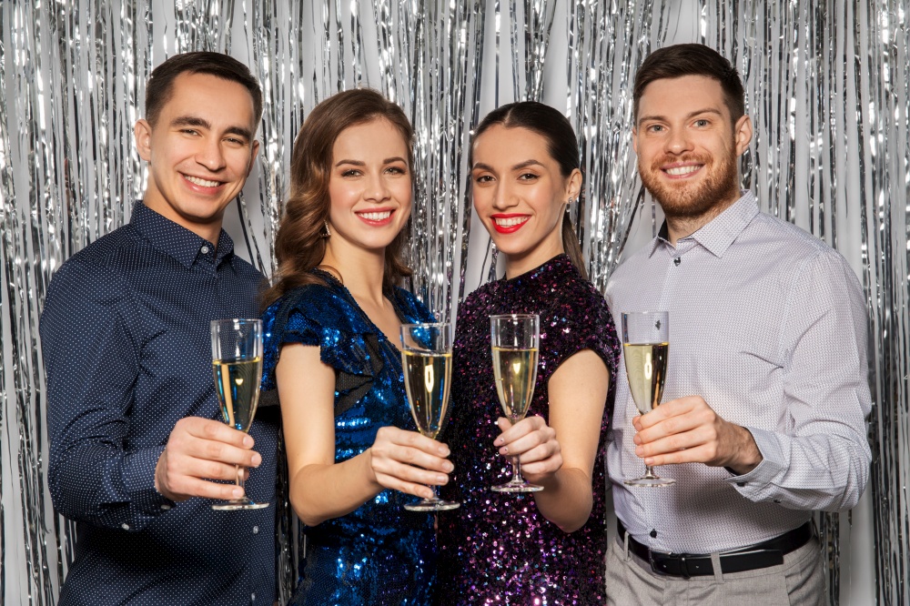 celebration and holidays concept - happy friends toasting champagne glasses at party. happy friends toasting champagne glasses at party