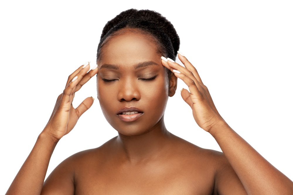 beauty and people concept - portrait of young african american woman with bare shoulders doing face massage over white background. portrait of african woman doing face massage