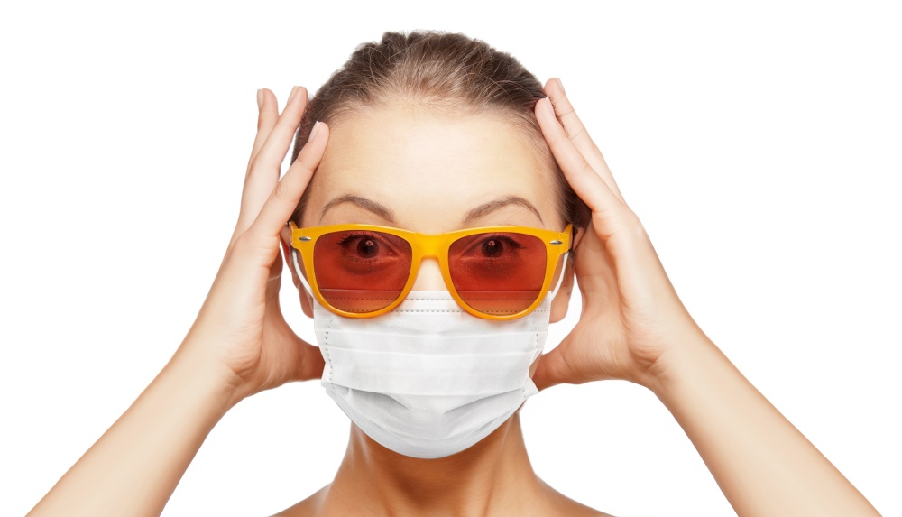 pandemic, health and people concept - portrait of surprised teenage girl in sunglasses wearing face protective medical mask for protection from virus disease. surprised teenage girl in mask and sunglasses
