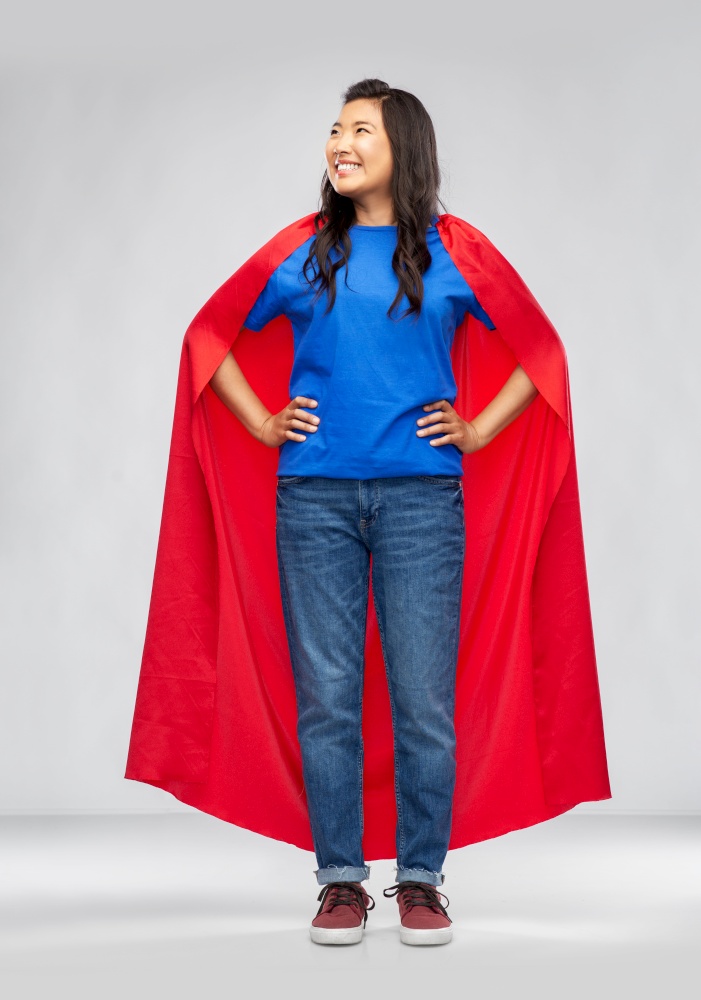women&rsquo;s power and people concept - happy asian woman in red superhero cape over grey background. happy asian woman in red superhero cape