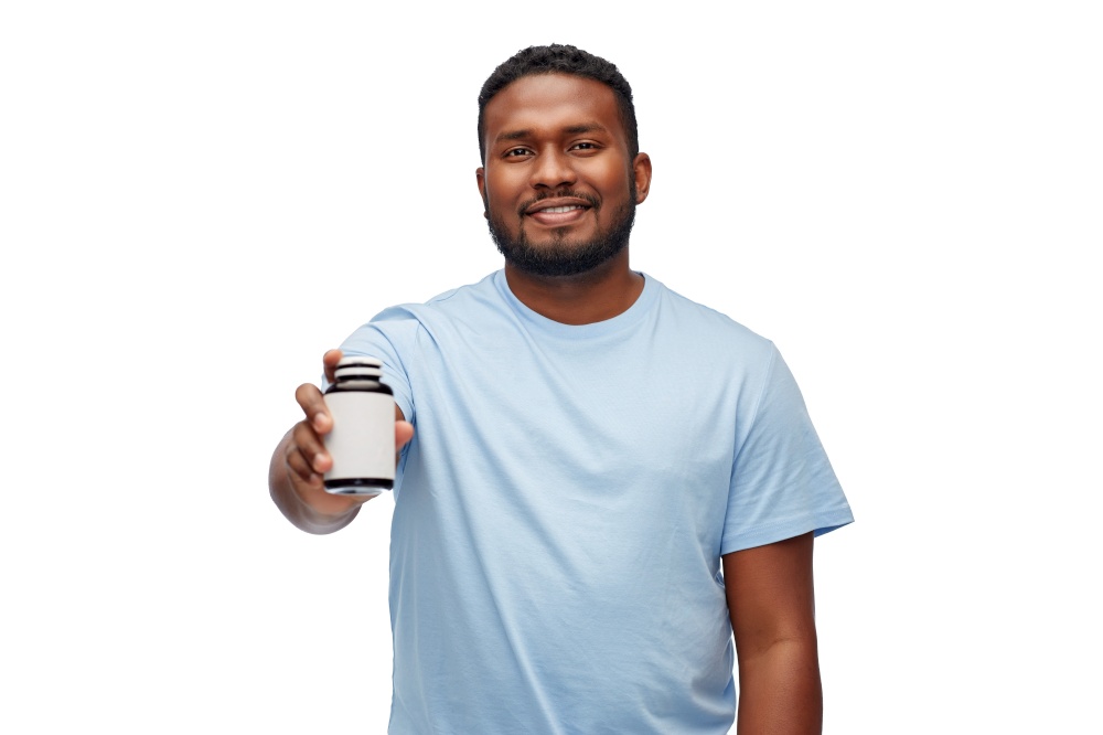 people and healthcare concept - portrait of happy smiling young african american man with medicine jar over white background. smiling african american man with medicine jar
