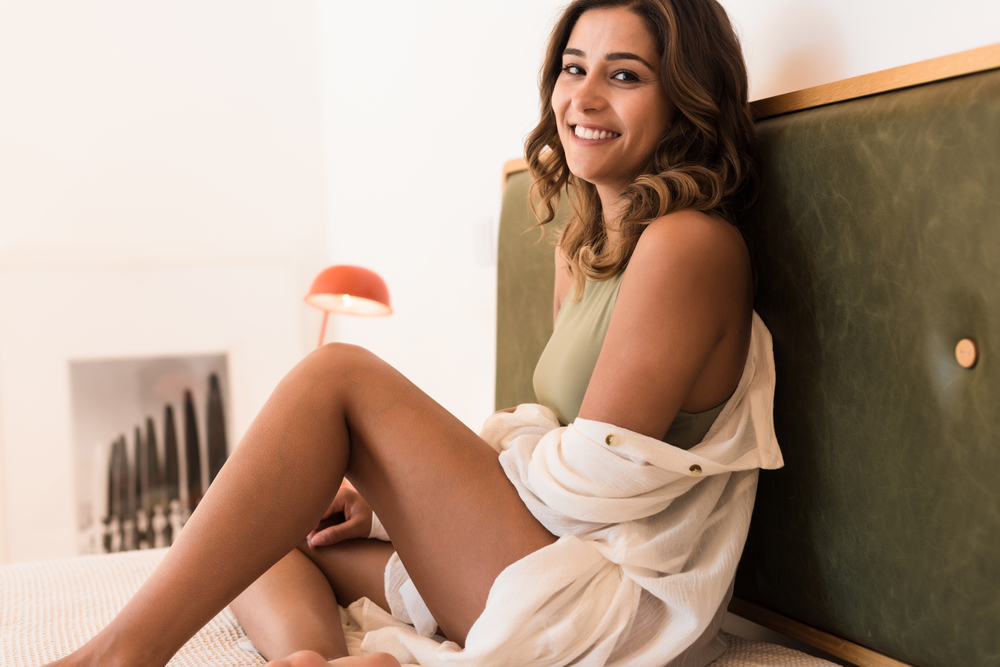 Modern and natural woman sitting on the bed with sexy clothes