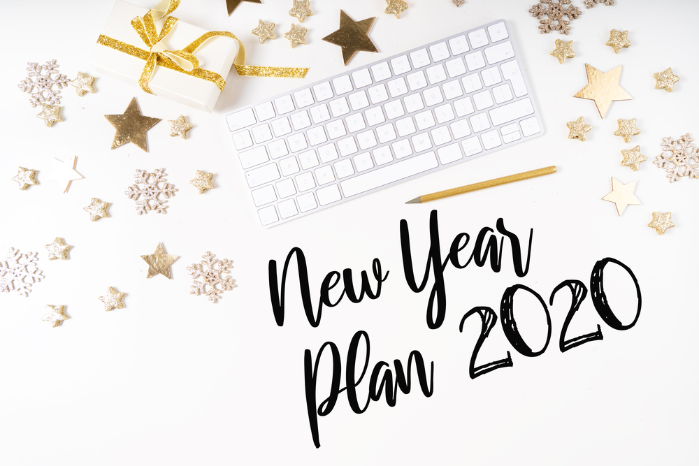 New 2020 year plan. Christmas home office desk with computer, notebook, gifts, christmas gold decorations. Flat lay, top view, copy space.. Christmas home office desk