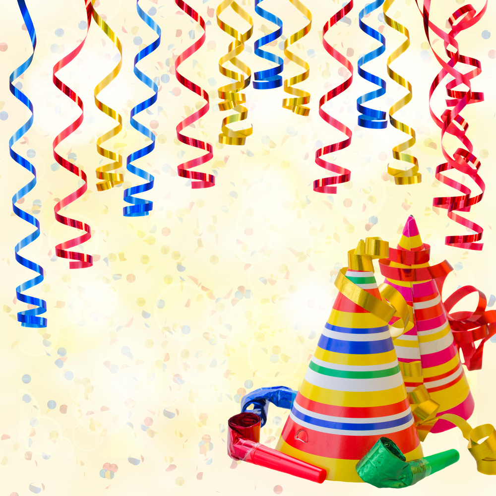 Birthday party background with curling stream paper, hats and whistles. Birthday party background