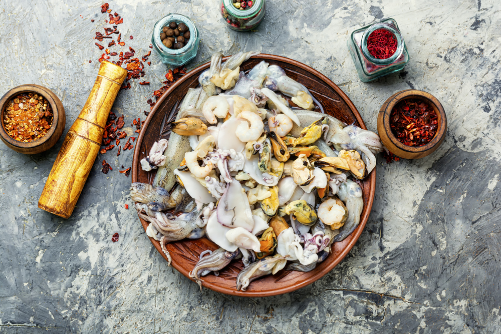 Raw seafood with fresh mussels,clams,squid, shrimps and spice. Fresh seafood on stone table