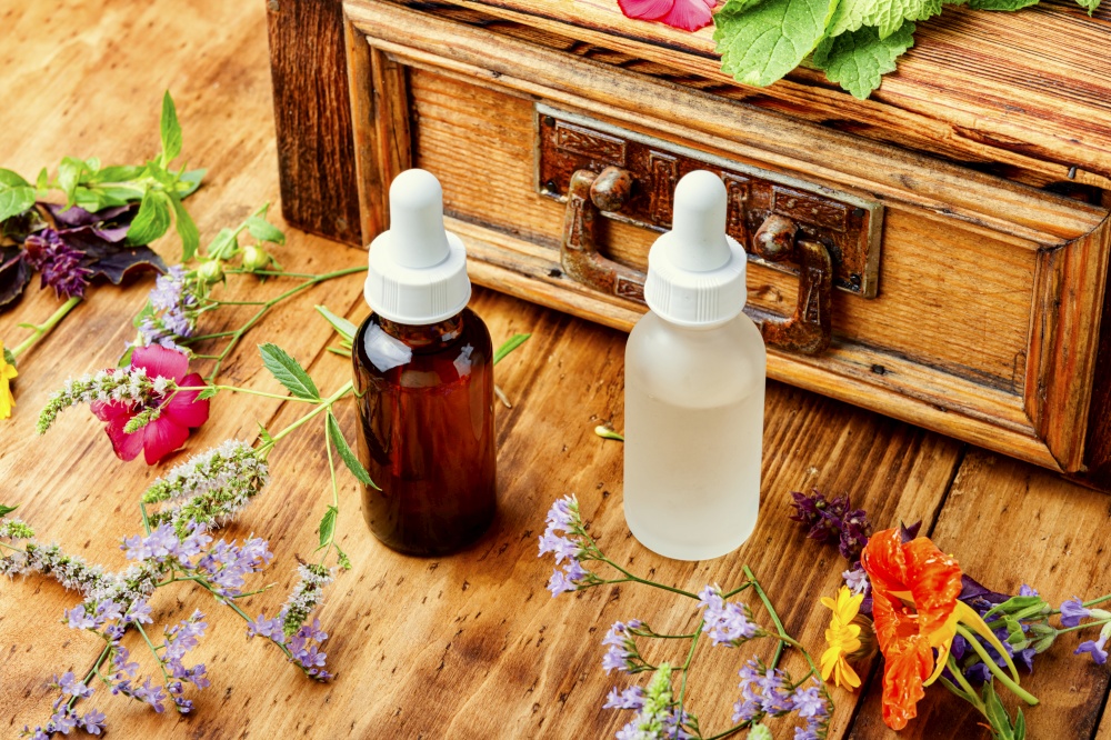 Bottles of essential oil with fresh herbs and flowers.Herbal medicine. Essential oils with herbs and flowers