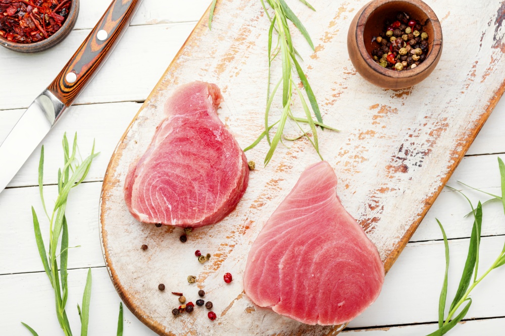 Fresh raw tuna steak on kitchen board. Raw tuna steak