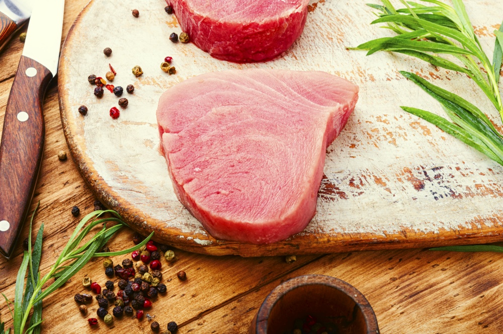 Steak of tuna fish on wooden table. Raw tuna steak