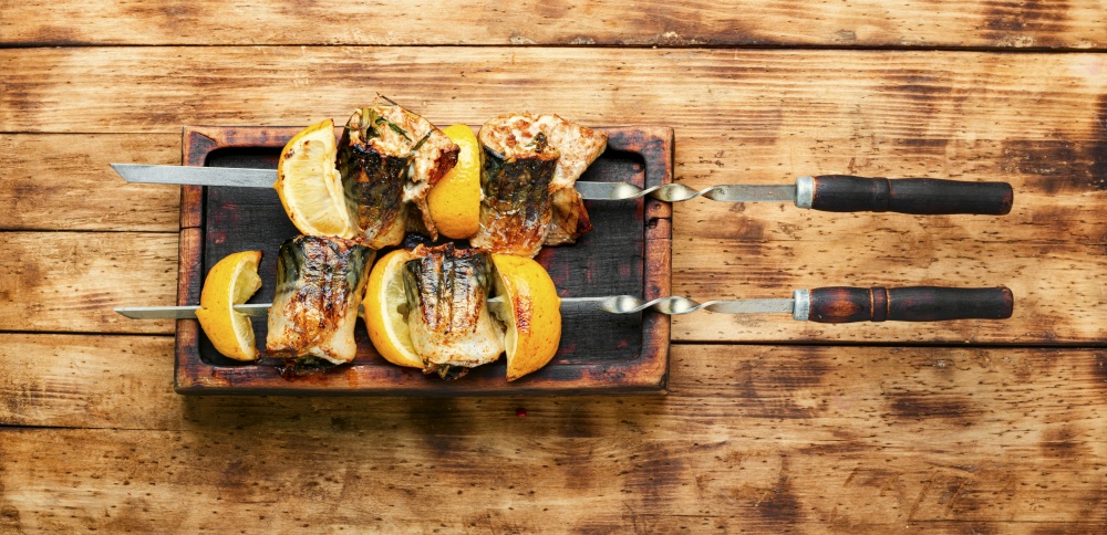 Grilled skewers of mackerel.Fish barbecue skewer on old wooden table. Barbecue mackerel fish on skewers