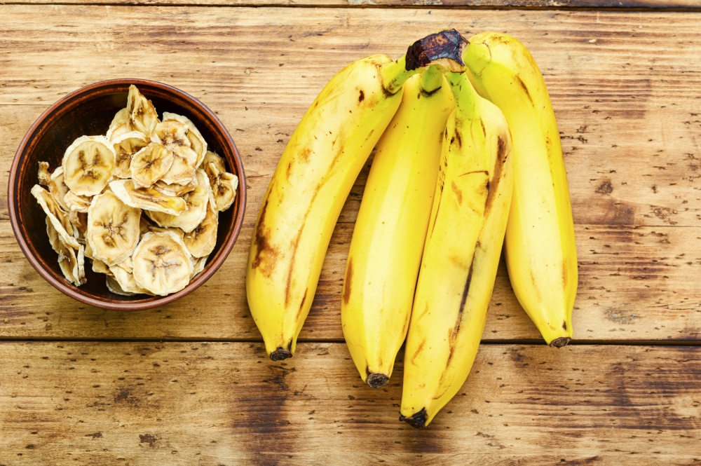 Ripe fresh and dried banana.Dried sweet on wooden background. Dried banana slices