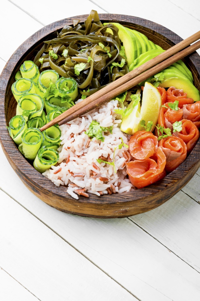 Hawaiian salmon poke bowl with rice,seaweed and avocado. Hawaiian poke bowl