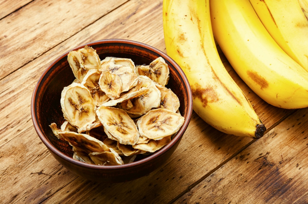 Ripe fresh and dried banana.Dried sweet on wooden background. Delicious dried bananas