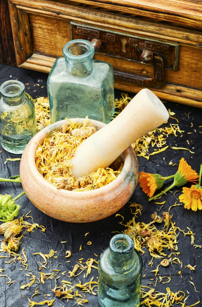 Calendula or marigold dry.Mortar with healing herbs.Herbal medicine. Dried calendula flower