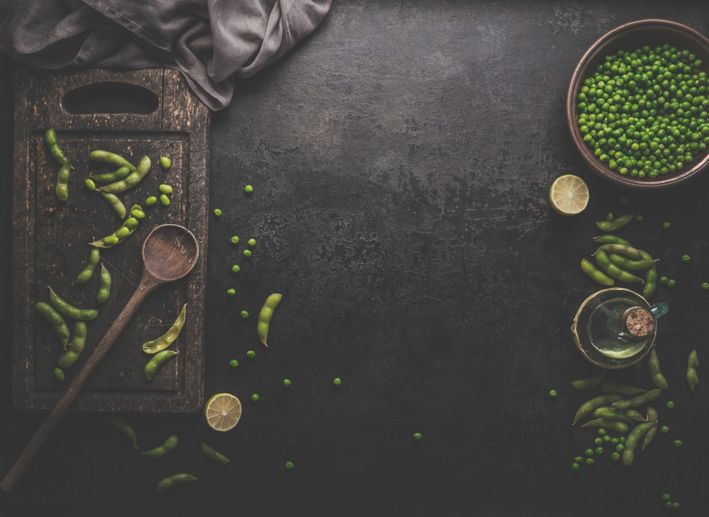 Green Edamame  soybeans  and green peas on dark rustic background. Healthy food cooking concept. Top view