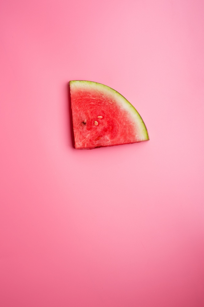 conceptual shot with slice of ripe watermelon at pink background