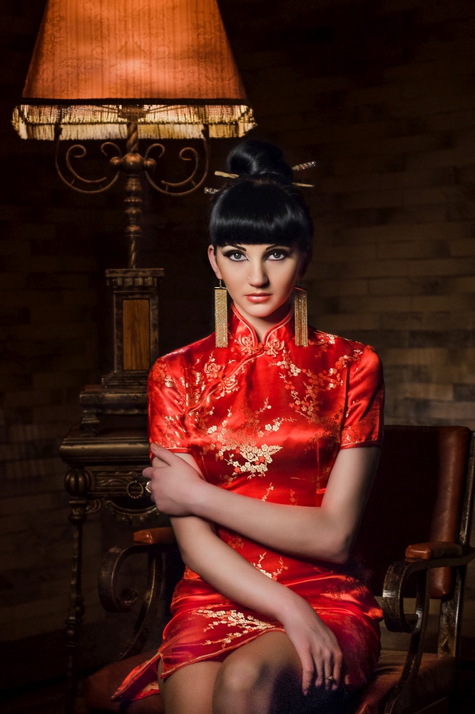 girl in a red Japanese silk dress qipao in a dark atmospheric room