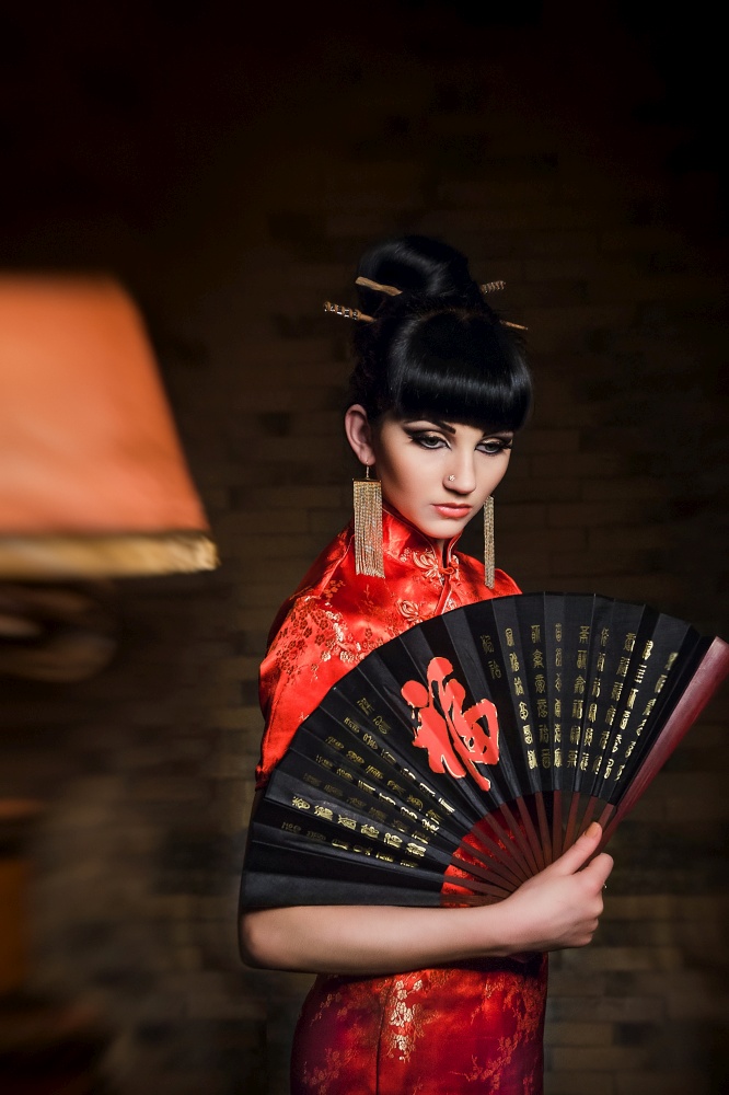 girl in a red Japanese silk dress qipao in a dark atmospheric room