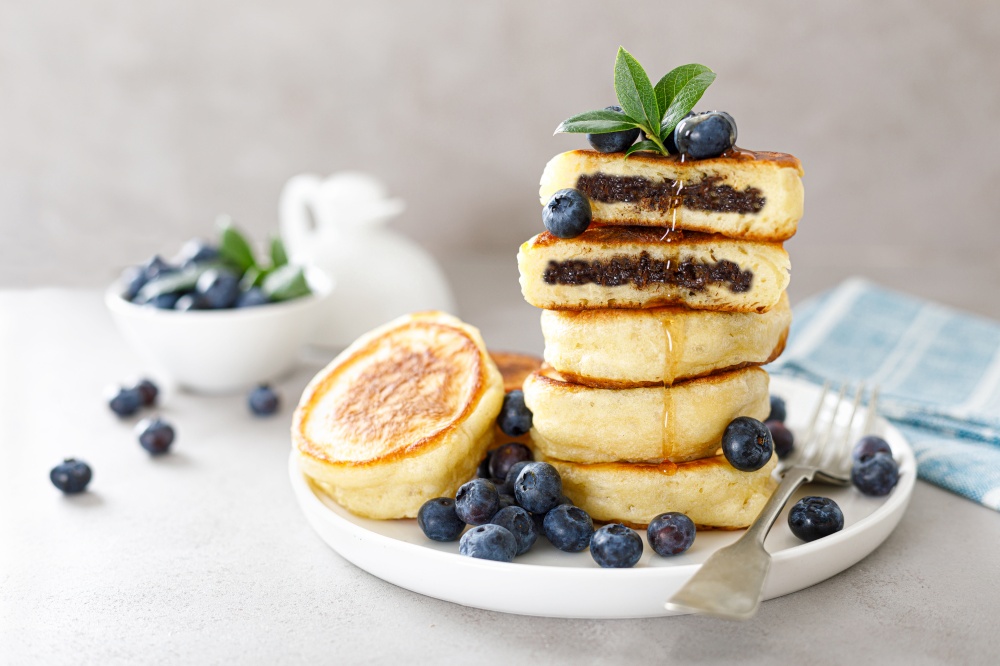 Fluffy souffle pancakes with chocolate filling and fresh blueberry for breakfast