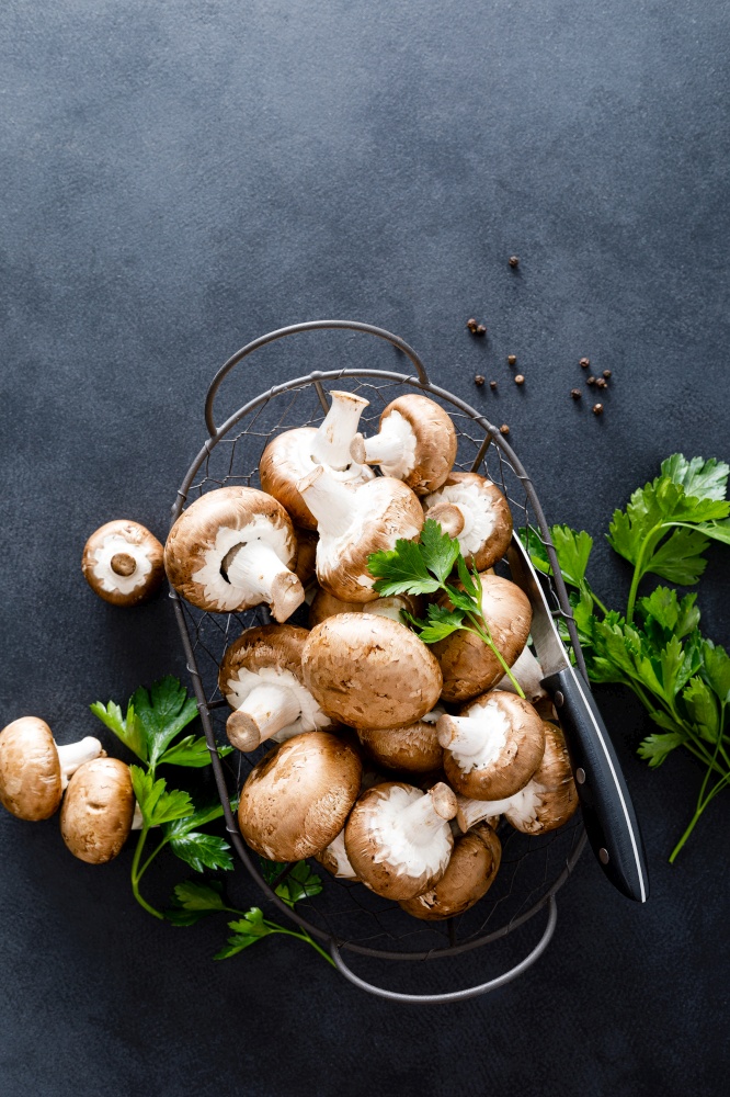 Raw mushrooms champignons on black background, cooking fresh champignons