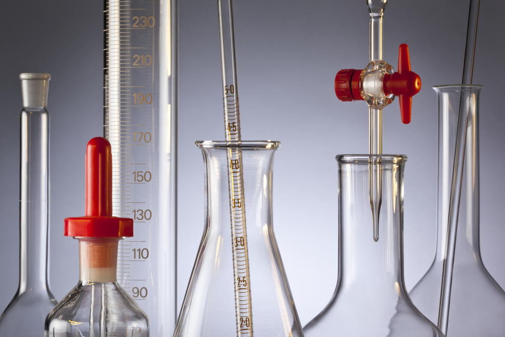 Chemical laboratory glassware - flasks, measuring cylinder, volumetric flask, pipette and a burette.