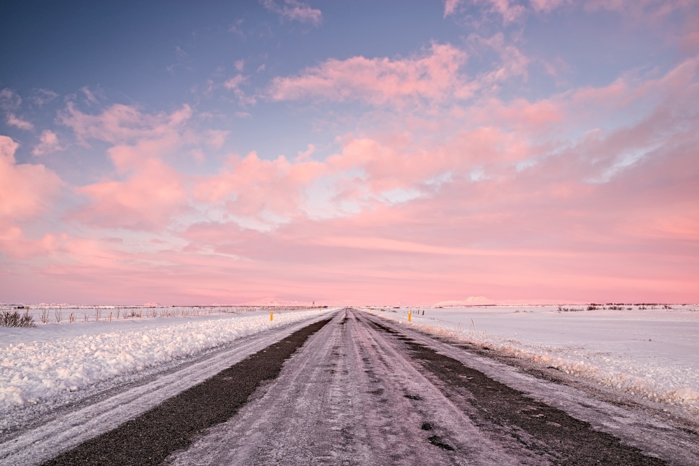 Pink sunset in an iced road in Iceland. Sunset in Iceland
