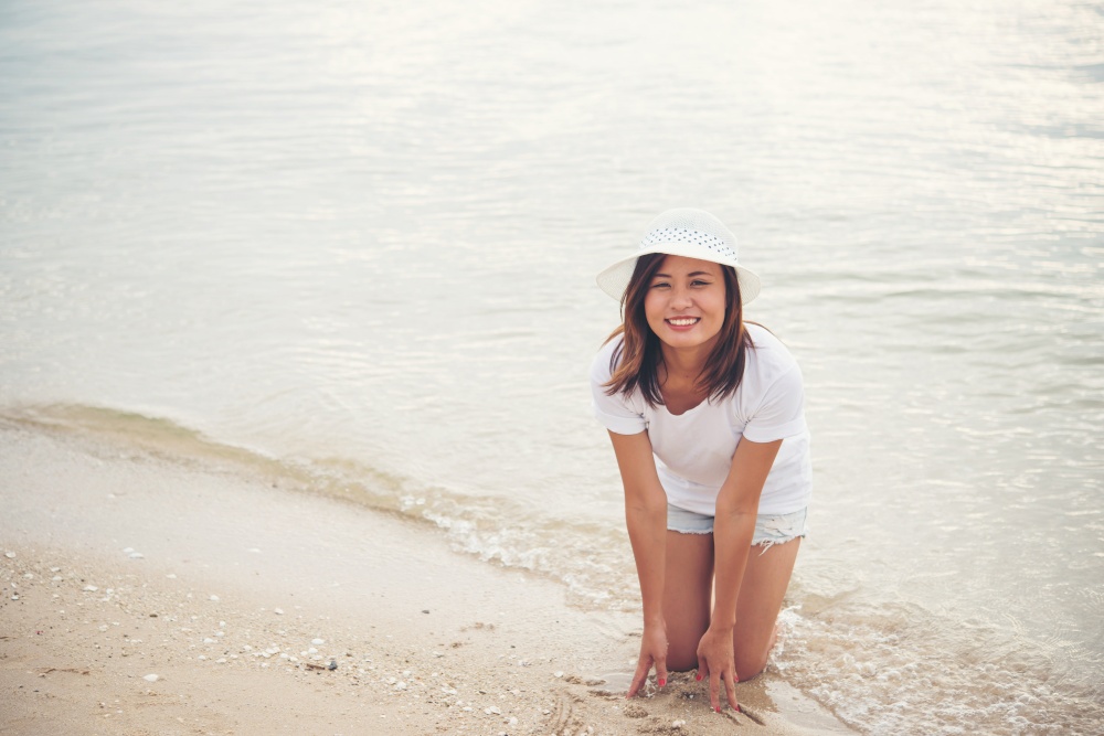 Happy young woman playing on beach at the vacation time.