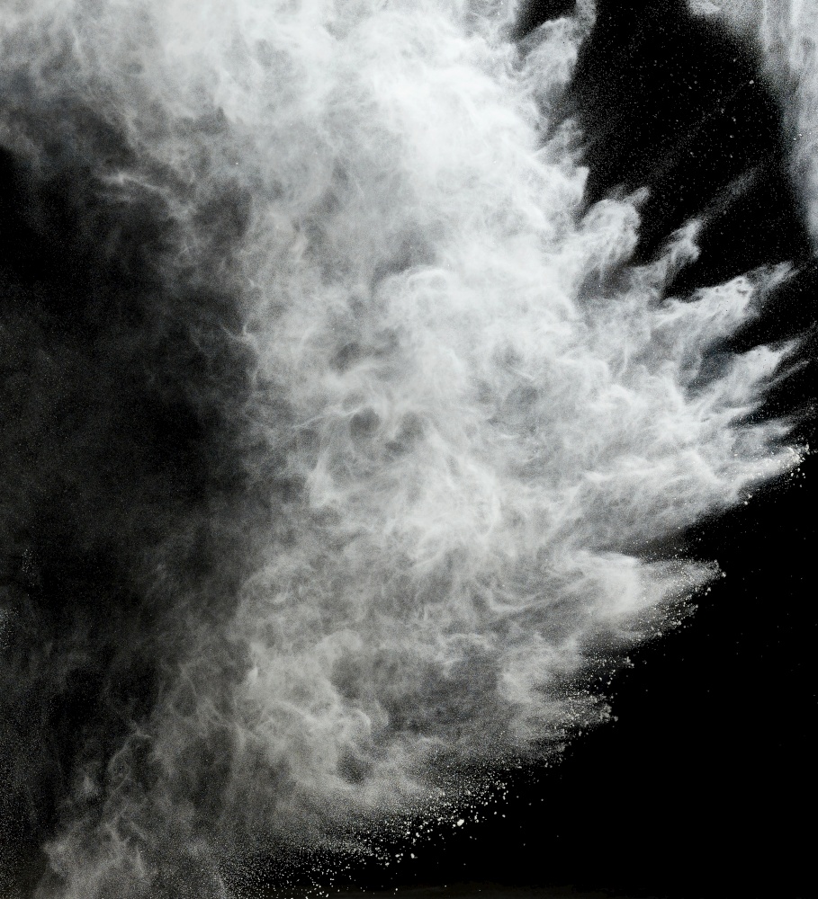 cloud of white wheat flour on a black background, particles fly in different directions, explosion and splash