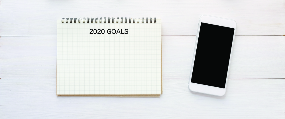 2020 goals on blank note paper and smart phone with blank screen on white marble background, 2020 new year aim to success in business background, mock up