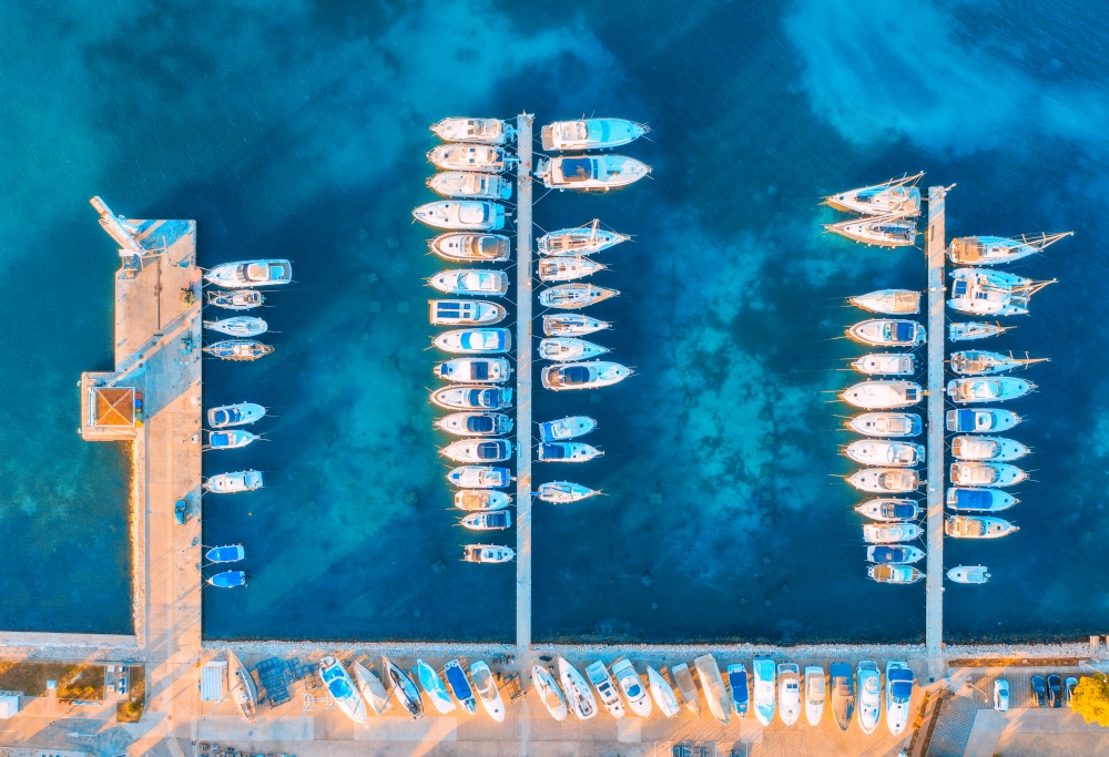 Aerial view of boats and yachts in port in beautiful old city at sunset in Croatia in summer. Landscape with motorboats in harbor, clear blue sea, cars, on the road. Top view