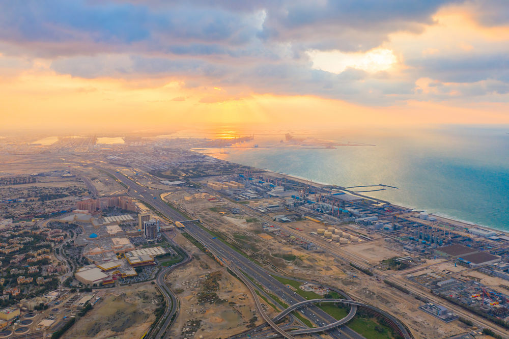 Aerial view of petrochemical oil refinery and sea in industrial engineering and energy concept in Dubai, urban city, UAE. Oil and gas tanks pipelines in industry. Modern metal factory. Power plant.