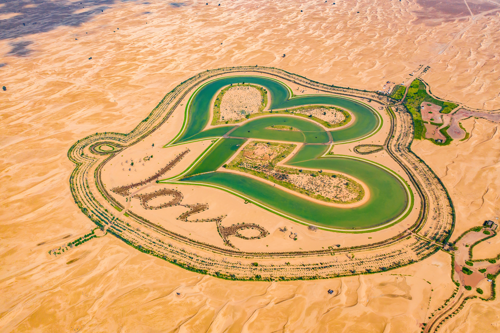 Aerial top view of love lake and sand desert, Heart shaped lakes in Al Qudra in Dubai, United Arab Emirates or UAE.  A new tourist destination for valentine day. Natural landscape background