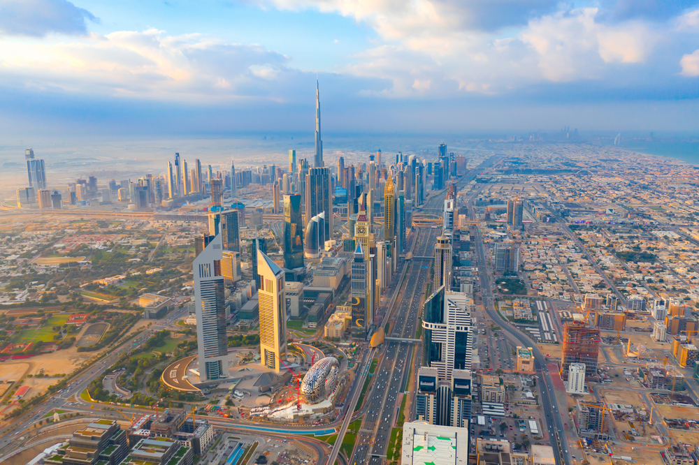 Aerial view of Burj Khalifa in Dubai Downtown skyline and highway, United Arab Emirates or UAE. Financial district and business area in smart urban city. Skyscraper and high-rise buildings at sunset.