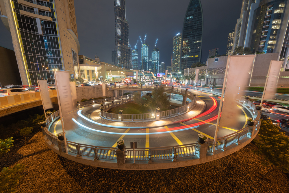 Structure of spiral circle ramp or road path way in Dubai Downtown skyline, United Arab Emirates or UAE. Financial district and business area in smart urban city. Skyscraper buildings at night.