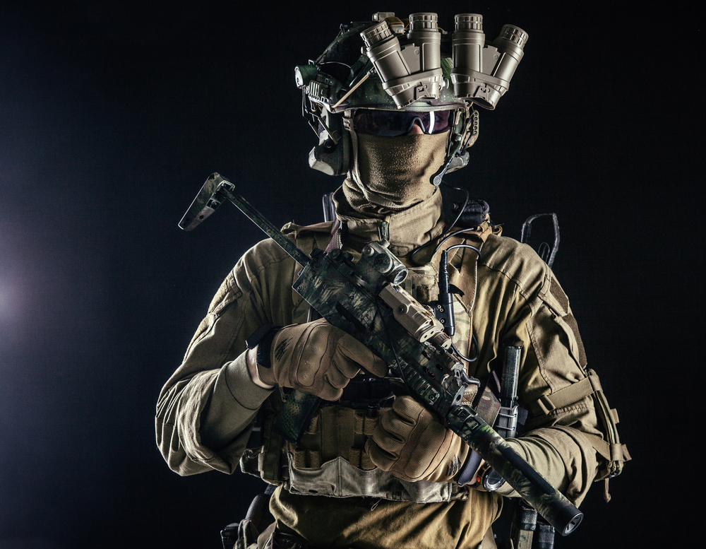 Elite commando fighter, private military company mercenary, special operations serviceman, security or secret service shooter equipped modern weapons and ammunition, studio shoot on black background. Military security service shooter soldier studio portrait