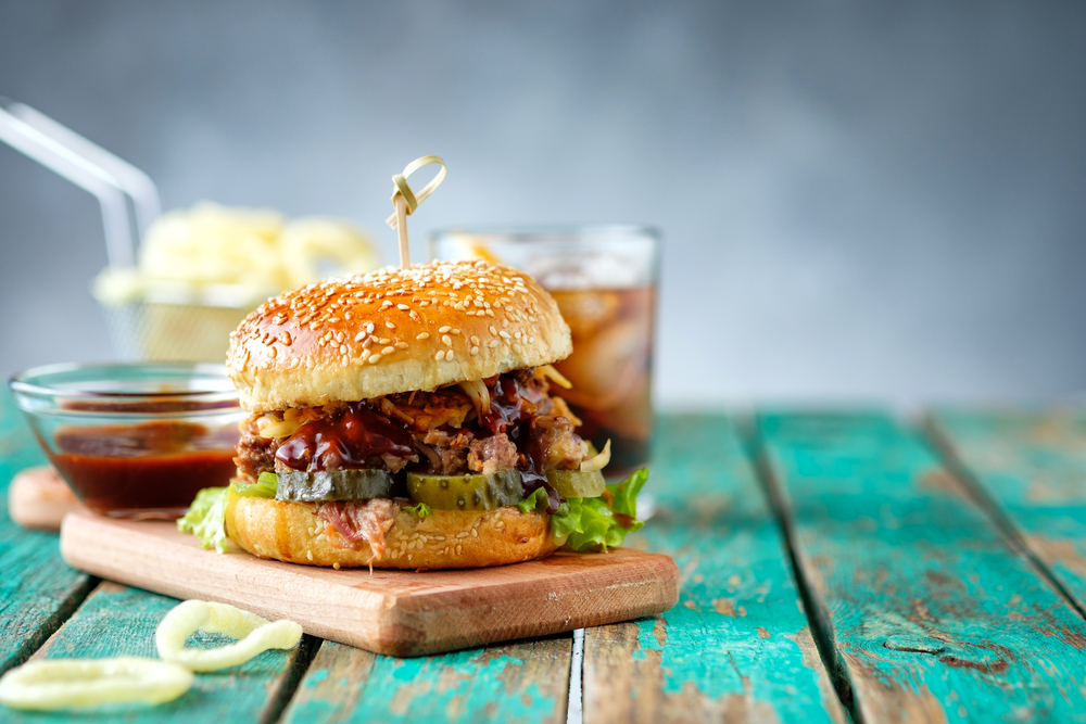 Gourmet Pulled Pork Burger with with Coleslaw and barbecue Sauce on  Wooden Table.