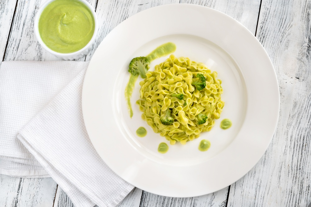 Portion of pasta with broccoli on white plate